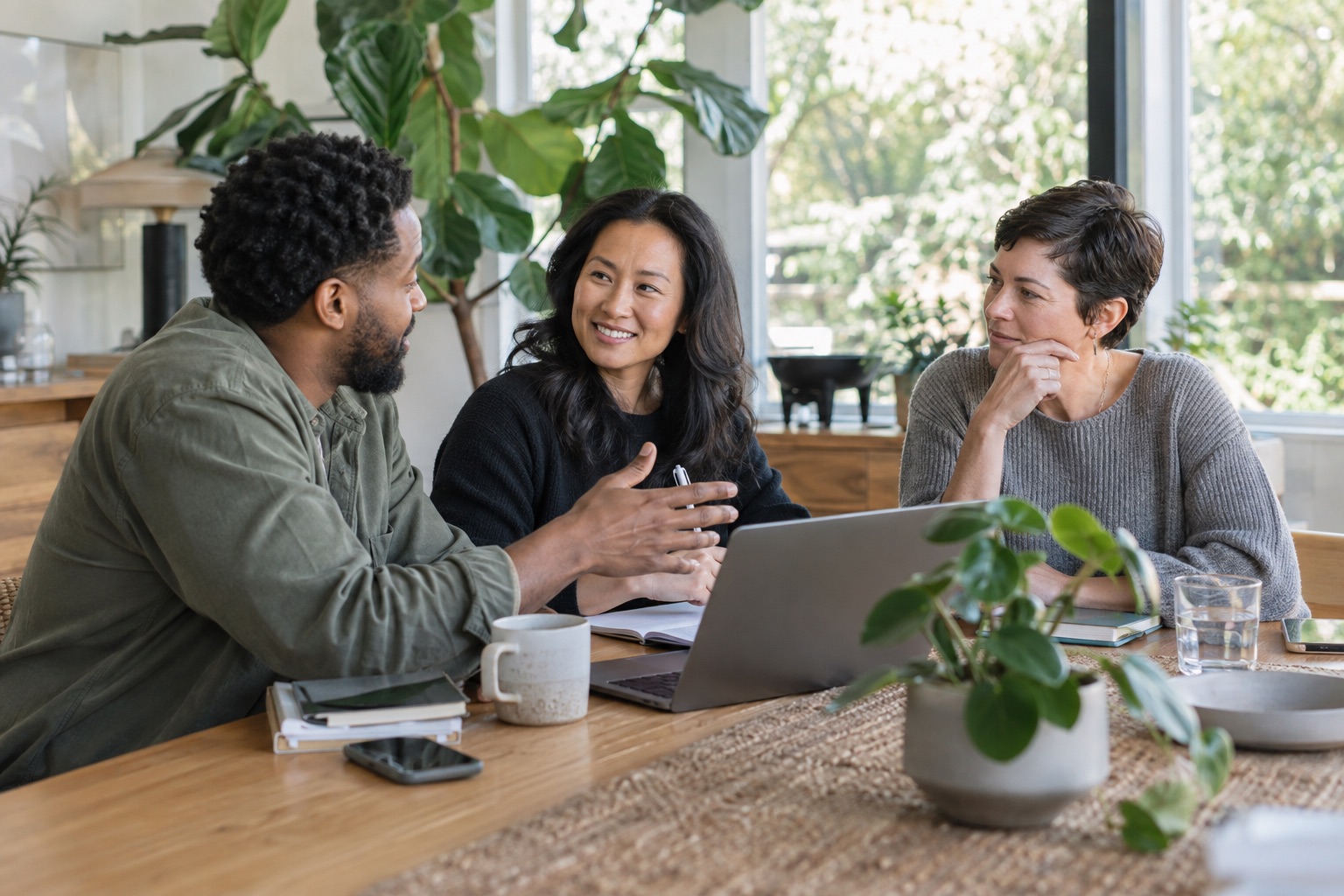 Colleagues talking around a table in a bright workspace, used as an illustration of collaboration